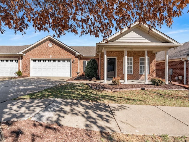 view of front of house with a garage, driveway, a porch, and brick siding