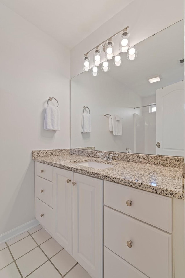 bathroom featuring tile patterned flooring, vanity, and baseboards