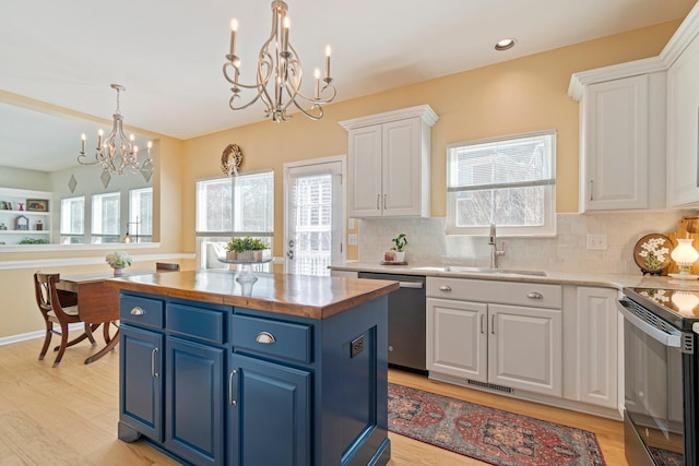 kitchen featuring white cabinets, electric range oven, blue cabinets, a sink, and stainless steel dishwasher