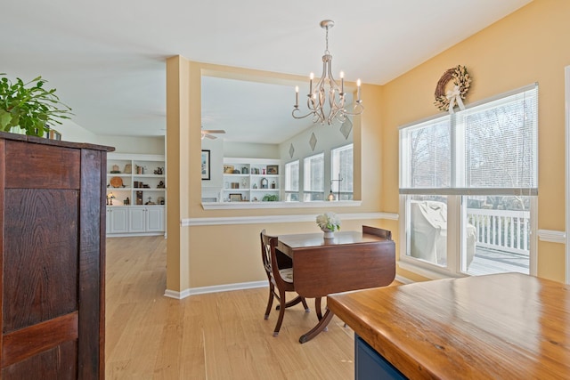 dining space featuring light wood finished floors, a ceiling fan, and baseboards