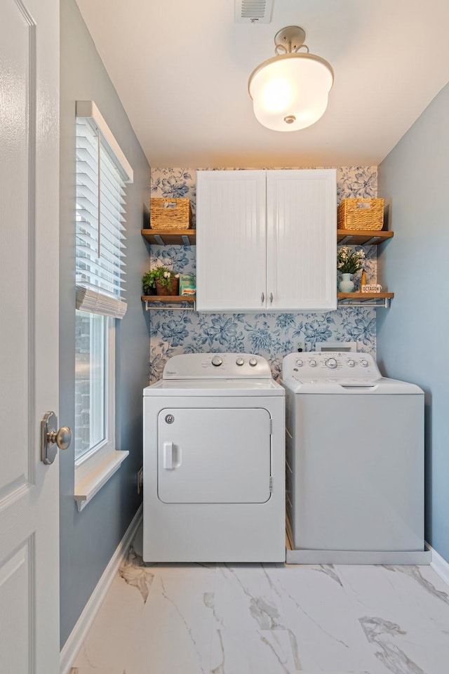 washroom featuring marble finish floor, washer and clothes dryer, visible vents, cabinet space, and baseboards