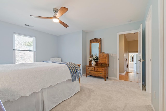 bedroom featuring baseboards, visible vents, ceiling fan, and light colored carpet