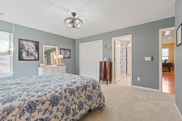 bedroom featuring carpet floors, a closet, multiple windows, and baseboards