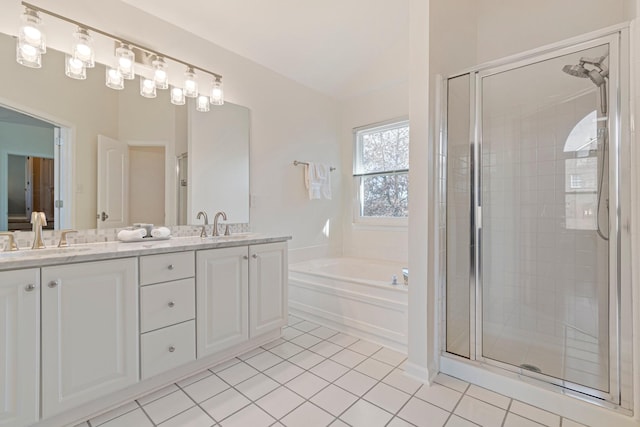 bathroom featuring double vanity, a stall shower, a sink, tile patterned flooring, and a bath