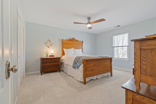 bedroom with baseboards, visible vents, a ceiling fan, and light colored carpet