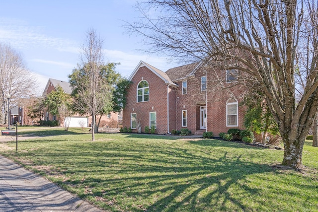 traditional-style house featuring brick siding and a front lawn