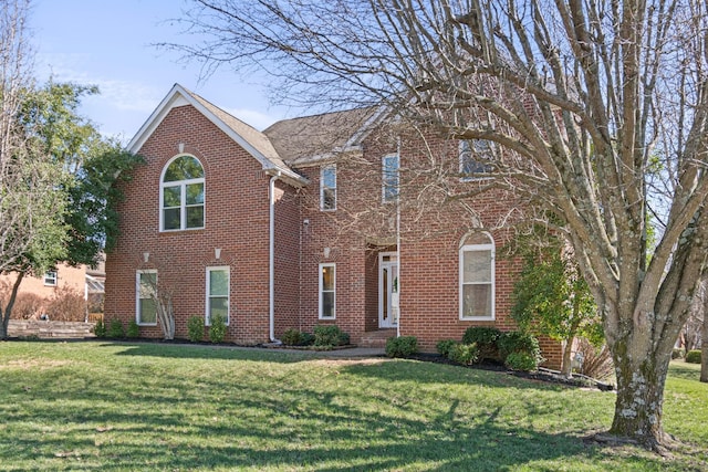 view of front of property featuring brick siding and a front yard