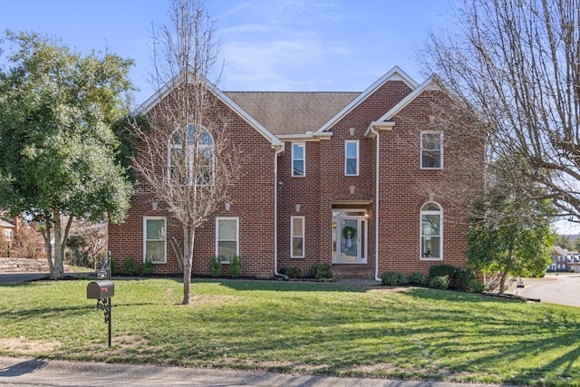 view of front of property with brick siding and a front yard