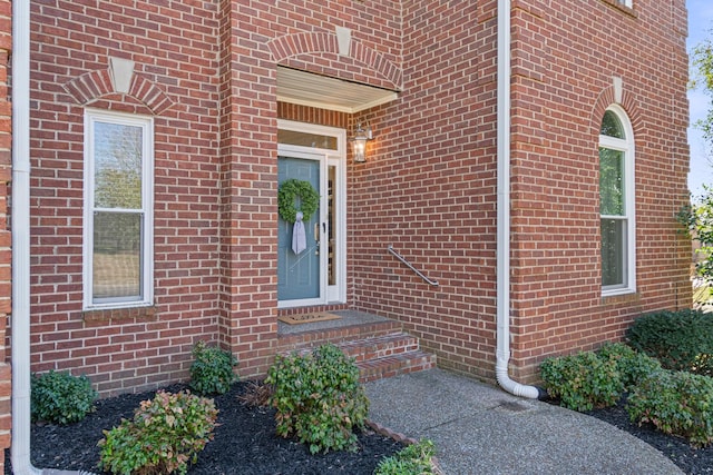 view of exterior entry with brick siding