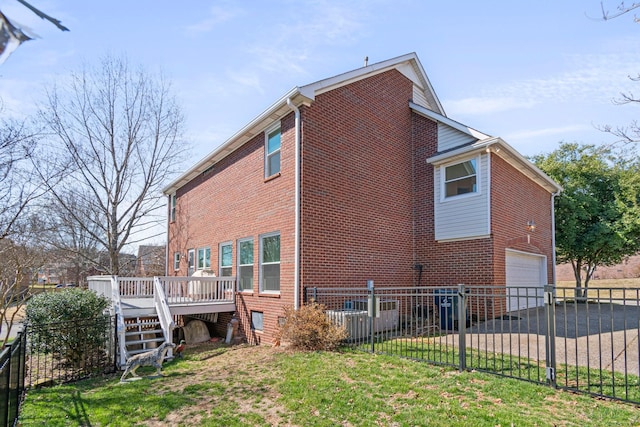 view of property exterior with driveway, an attached garage, fence, a wooden deck, and brick siding