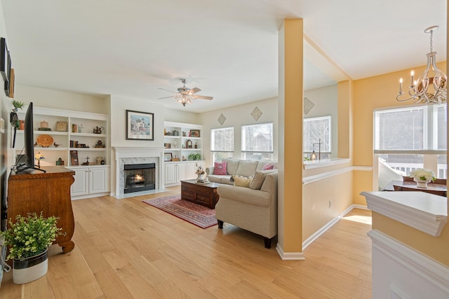 living area with light wood-type flooring, plenty of natural light, baseboards, and a premium fireplace