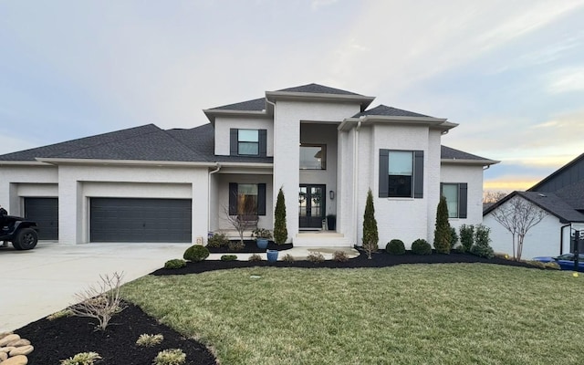 prairie-style house featuring a garage, concrete driveway, a front lawn, and brick siding