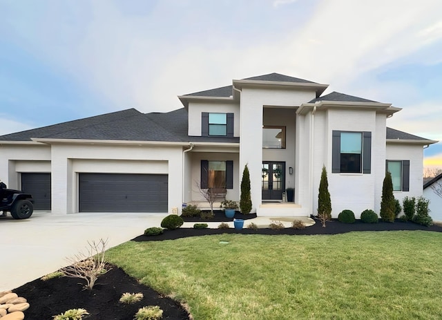 prairie-style house with a garage, driveway, and a front yard