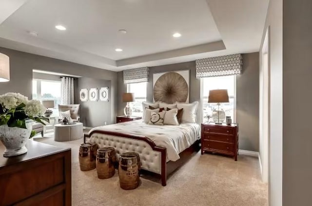 bedroom featuring recessed lighting, a raised ceiling, light colored carpet, and baseboards