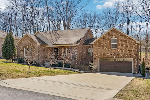 view of front of house featuring an attached garage, brick siding, driveway, and a front yard