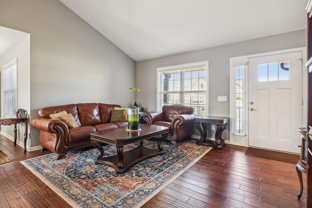 living room with dark wood-type flooring, lofted ceiling, and baseboards