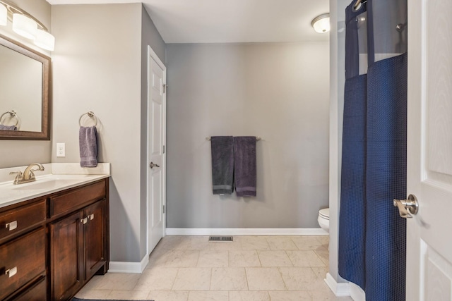 bathroom featuring visible vents, toilet, vanity, and baseboards