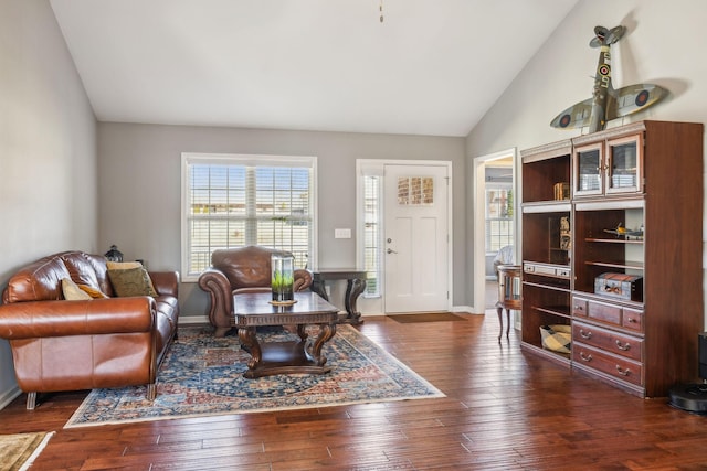 living room featuring high vaulted ceiling, baseboards, and hardwood / wood-style flooring