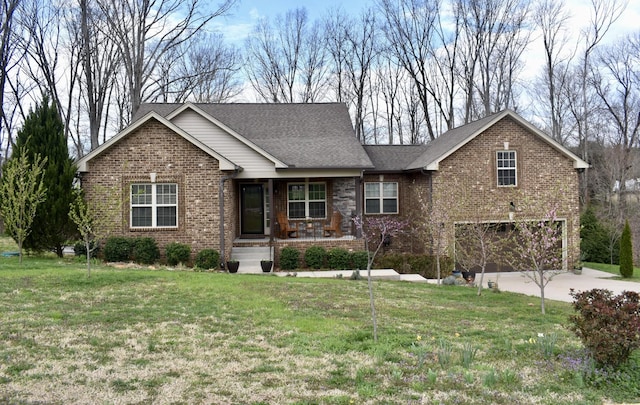 craftsman house featuring concrete driveway, a front yard, covered porch, brick siding, and a garage