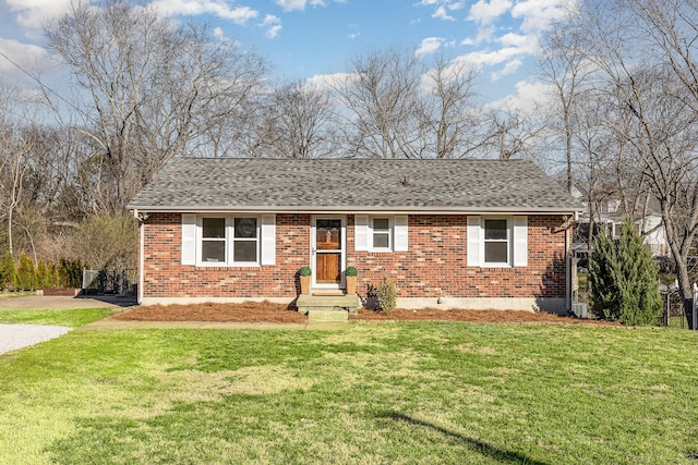 single story home featuring a front lawn, roof with shingles, and brick siding