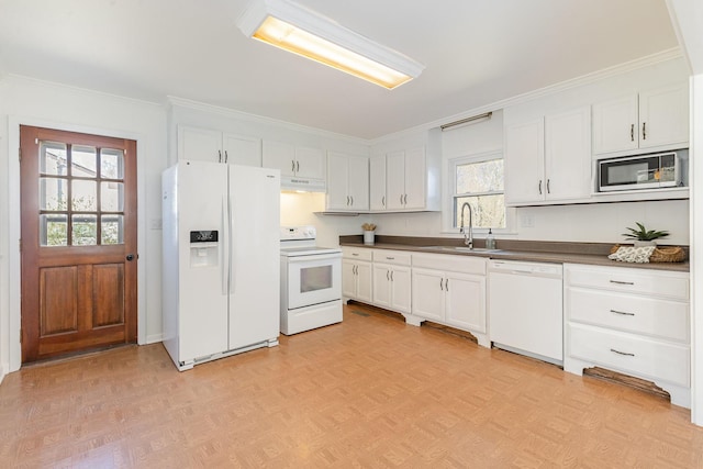 kitchen with dark countertops, white cabinetry, a sink, white appliances, and under cabinet range hood