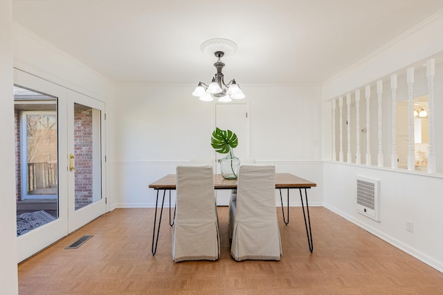 dining space with a chandelier, visible vents, french doors, heating unit, and crown molding