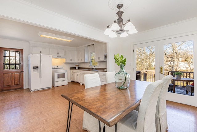 dining area with a notable chandelier, plenty of natural light, and crown molding