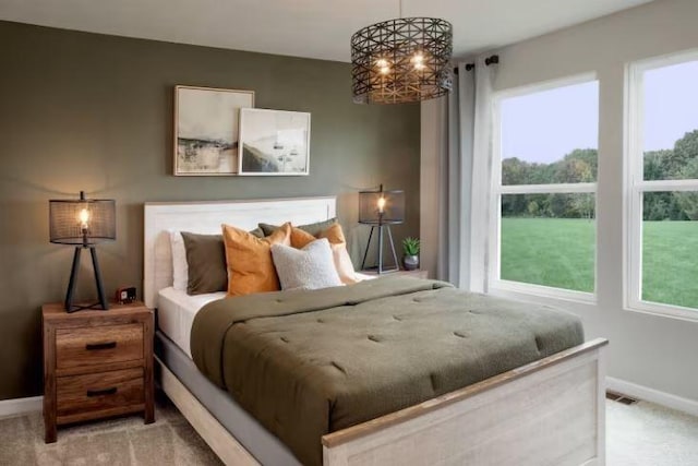 bedroom featuring a chandelier, carpet, and baseboards