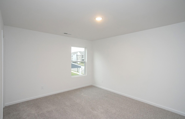 spare room with visible vents, baseboards, and carpet floors