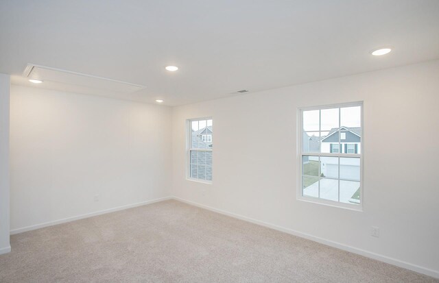 unfurnished room with recessed lighting, baseboards, carpet, and attic access