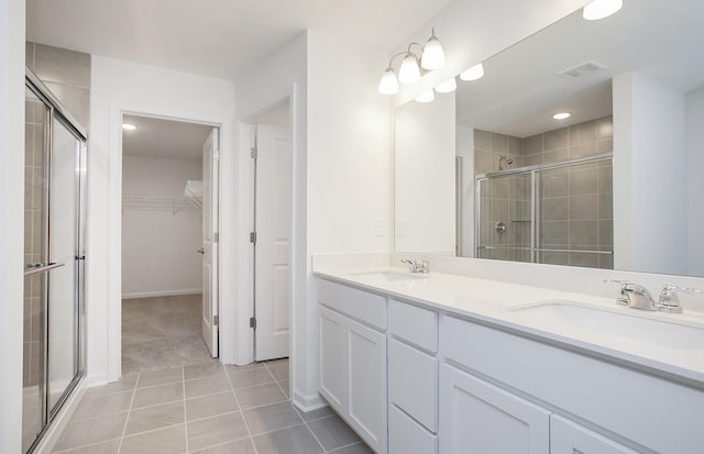 full bathroom with a sink, visible vents, a stall shower, and a spacious closet