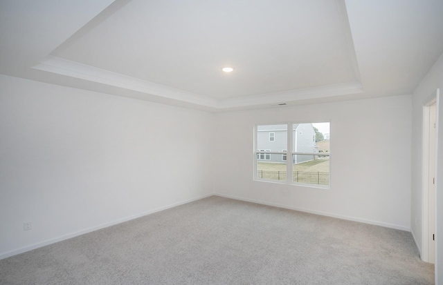 carpeted empty room with recessed lighting, baseboards, a raised ceiling, and crown molding