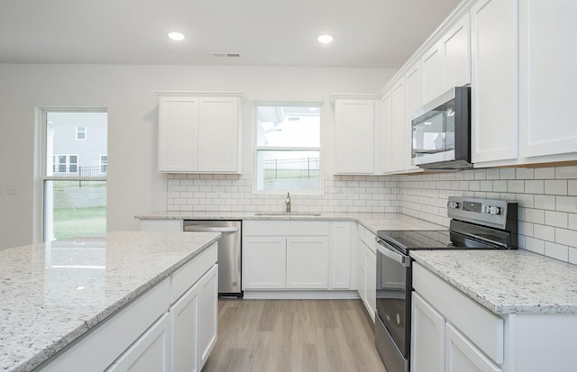 kitchen with white cabinetry, visible vents, appliances with stainless steel finishes, and a sink