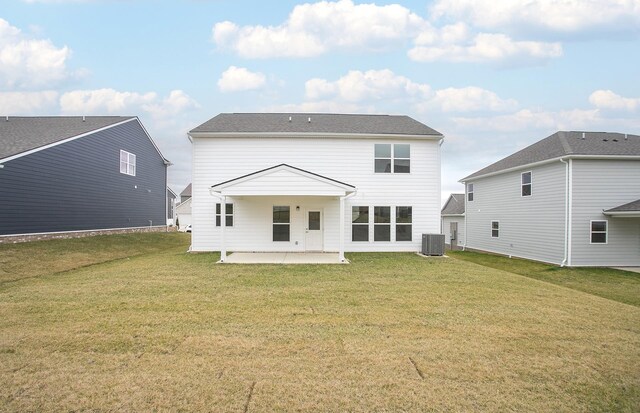 back of property with central air condition unit, a lawn, and a patio