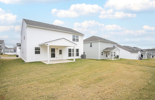 back of property featuring a residential view, a patio area, a lawn, and central AC