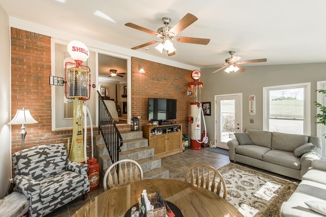 living area featuring stairway, brick wall, ornamental molding, and stone finish flooring