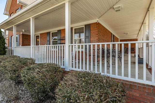 view of property exterior with a porch and brick siding