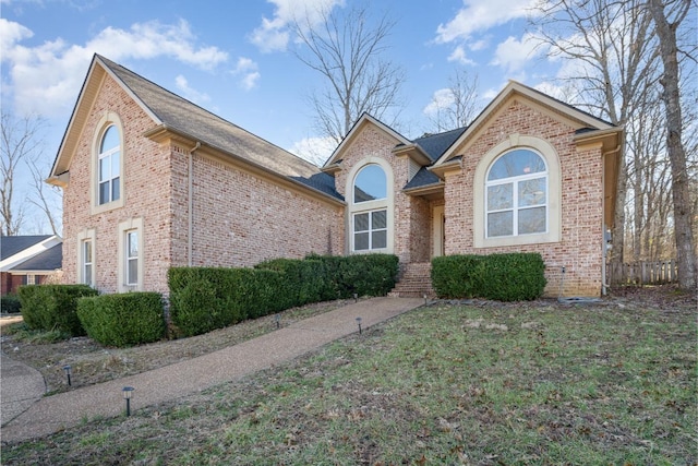 view of front of property with a front yard and brick siding