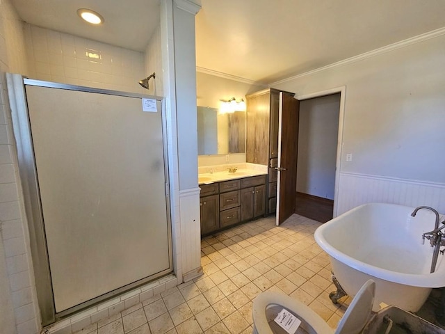 bathroom with a wainscoted wall, vanity, a freestanding bath, ornamental molding, and a stall shower