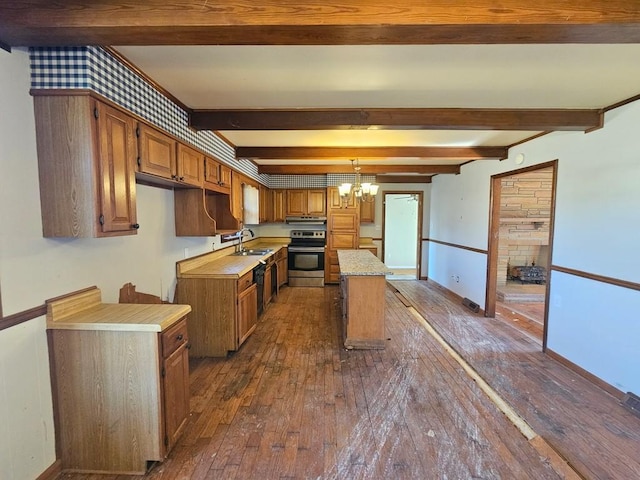 kitchen with electric range, dark wood finished floors, a kitchen island, light countertops, and a chandelier