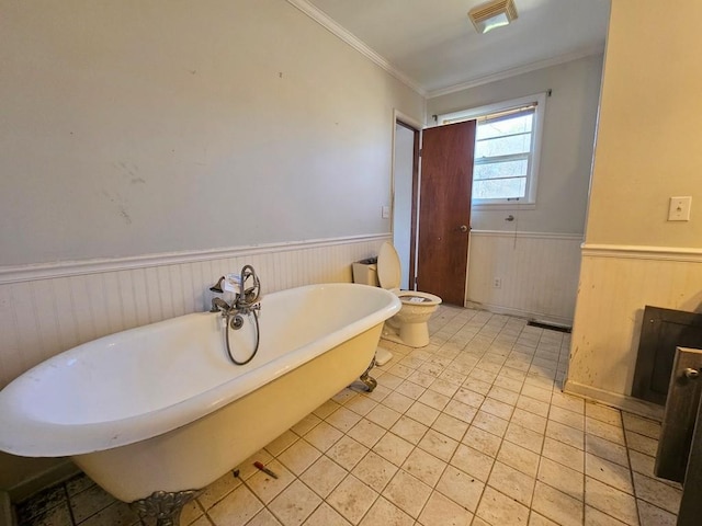 full bathroom with visible vents, toilet, a wainscoted wall, ornamental molding, and a freestanding tub