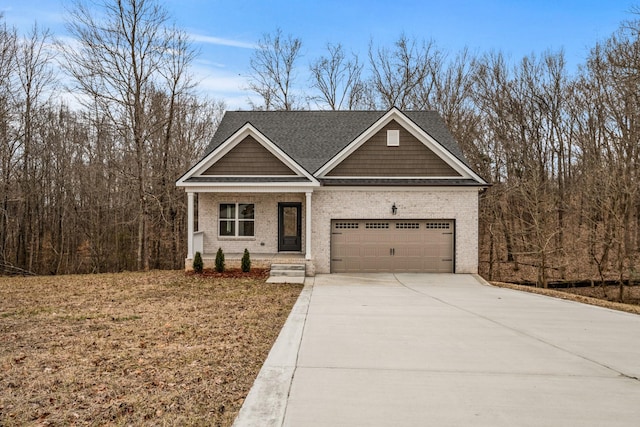 craftsman house with a garage, driveway, brick siding, and a porch