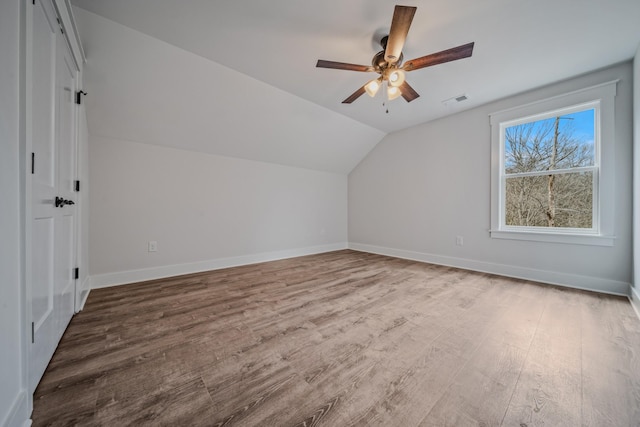 additional living space featuring vaulted ceiling, ceiling fan, wood finished floors, and baseboards