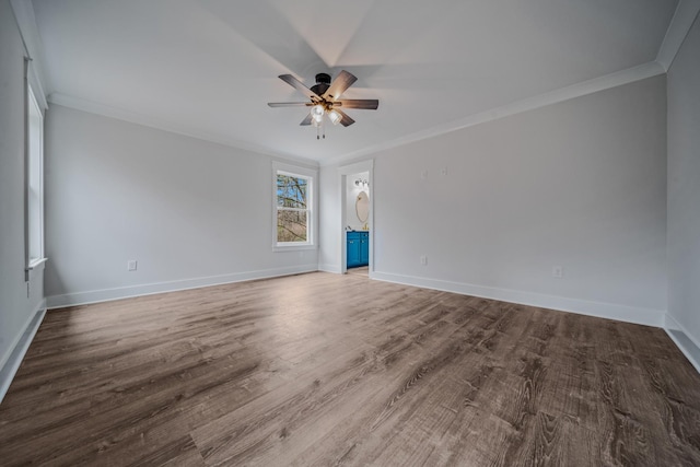 empty room with ceiling fan, baseboards, crown molding, and wood finished floors