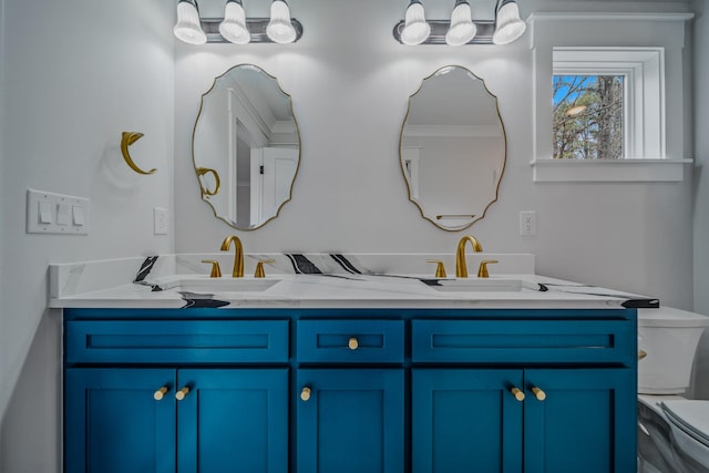 full bath featuring toilet, double vanity, and a sink