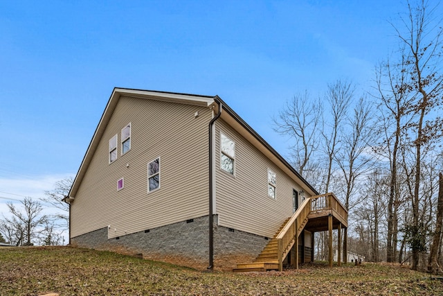 view of side of home with a deck, crawl space, and stairway