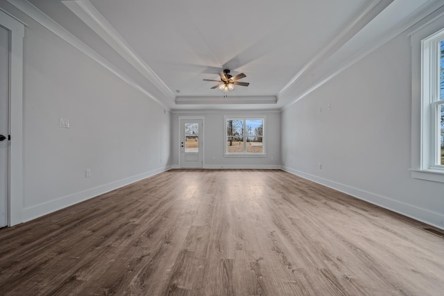 unfurnished living room featuring baseboards, a tray ceiling, and wood finished floors