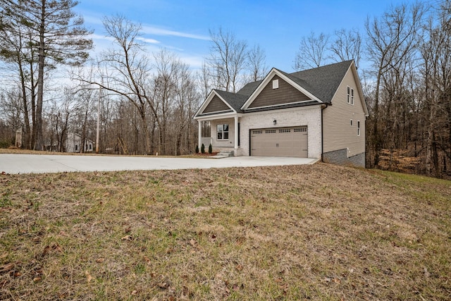 view of front of home with concrete driveway, brick siding, and a front yard