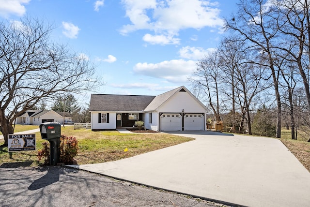 view of front of house with an attached garage, concrete driveway, and a front yard