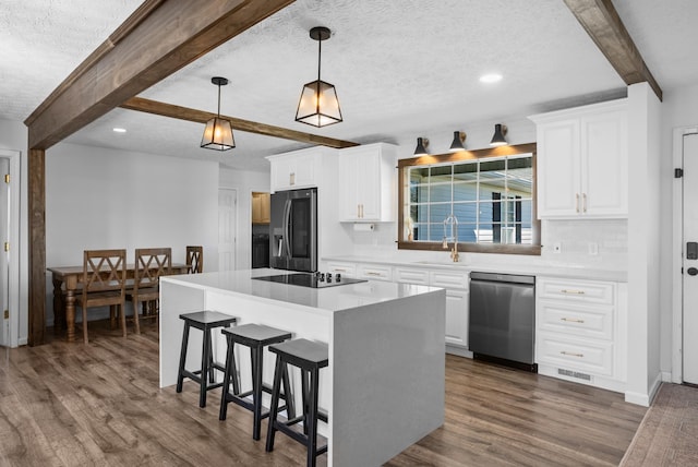 kitchen with tasteful backsplash, dark wood-style flooring, beamed ceiling, stainless steel appliances, and a sink